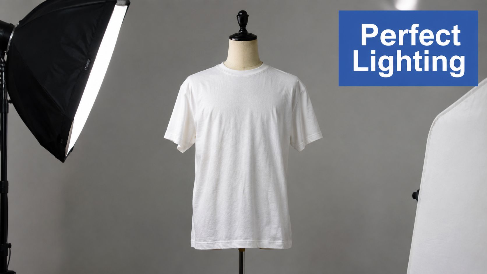 A white t-shirt on a mannequin in a professional studio setting with soft lighting equipment.