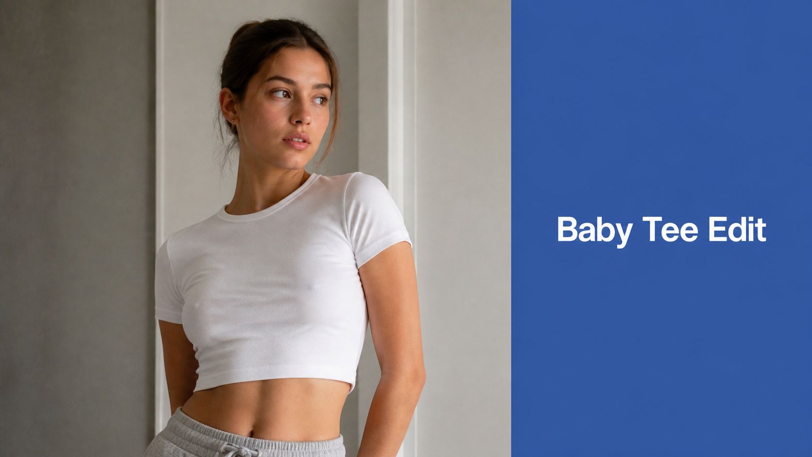 A young woman wearing a plain white cropped baby tee and gray sweatpants, looking off to the side.